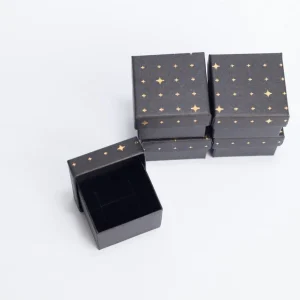 Cutie bijuterii neagră cu stele aurii din carton negru, decor elegant și cadou ideal pentru sărbători.