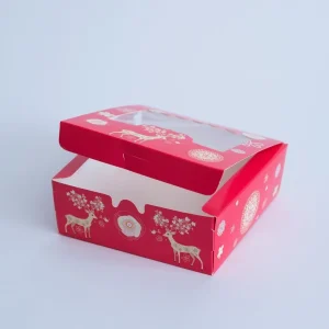 Cutie Crăciun roșie cu fereastră – ren și flori 14×14×5 cm din carton gros, decor elegant și cadou ideal pentru sărbători.