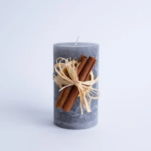 Lumânare decorativă gri cu portocală uscată și scorțișoară din material nedefinit, decor elegant și cadou ideal pentru sărbători.